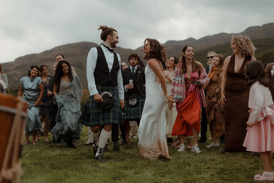 outdoor wedding ceilidh of bride and groom dancing at Carrick Castle Estate
