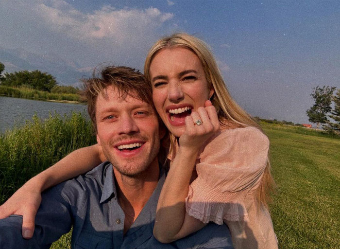 Emma Roberts and Cody John smile and show off Emma's engagement ring in a field