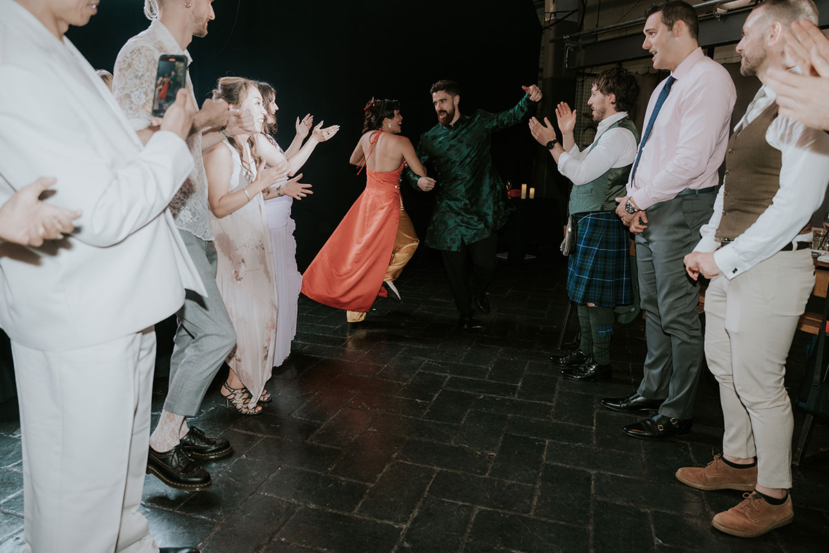 Guests performing ceilidh dancing at Barras Art and Design Glasgow wedding reception dancefloor