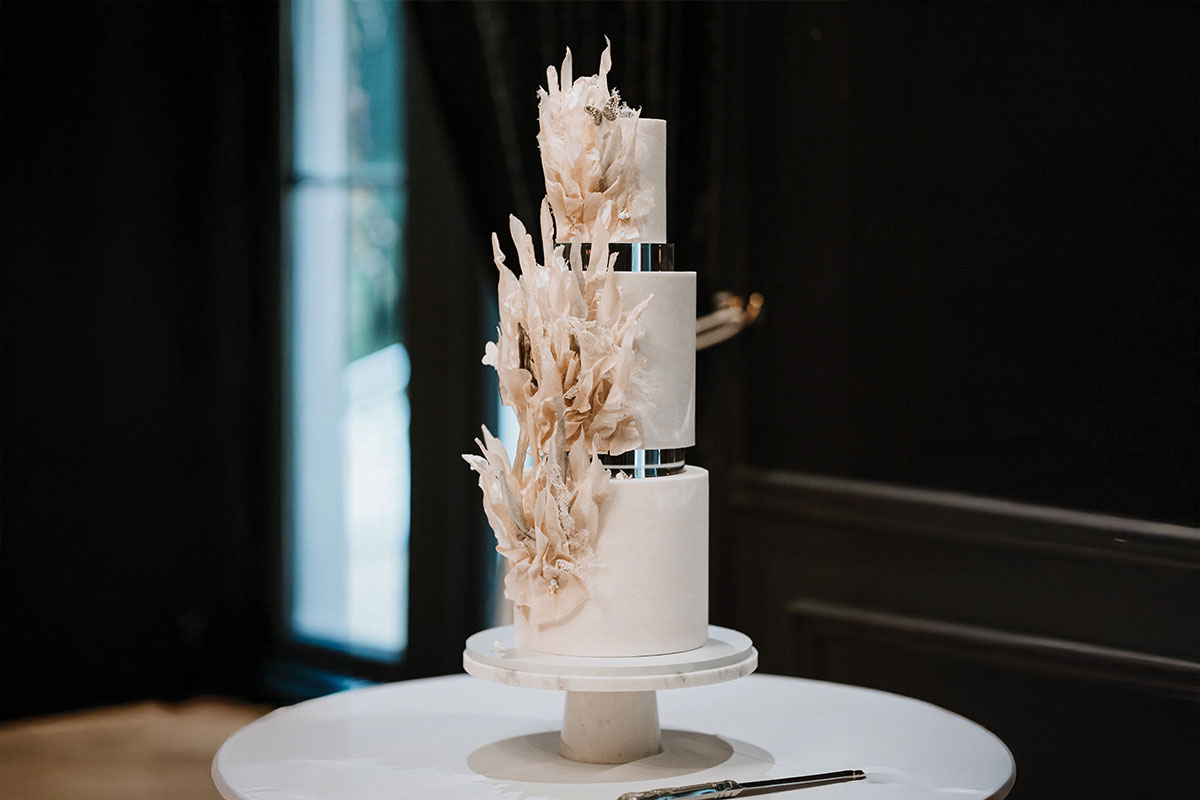 a three tier wedding cake with elaborate fondant and butterflies