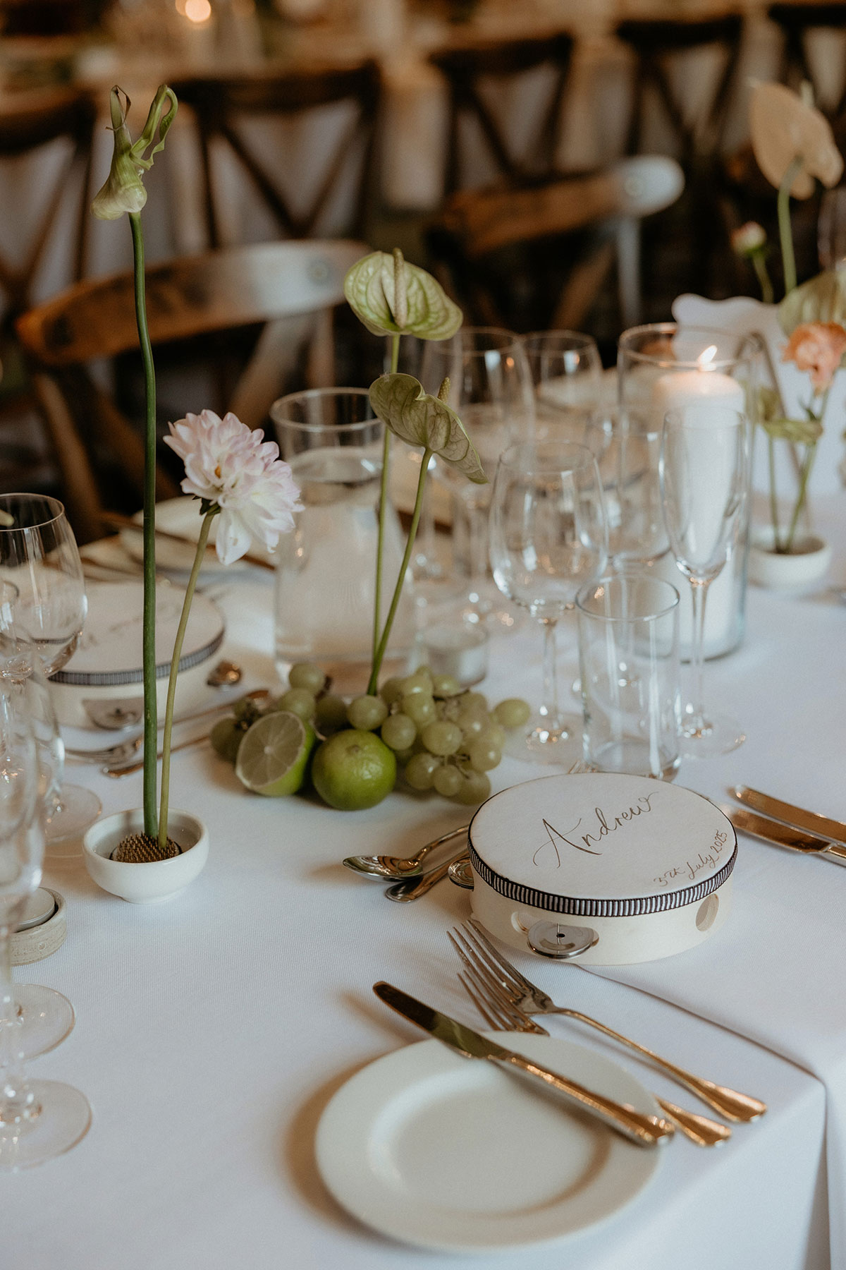 Wedding table styling with personalised tambourine favours, grapes and limes at Rosebery Steading reception in Midlothian.