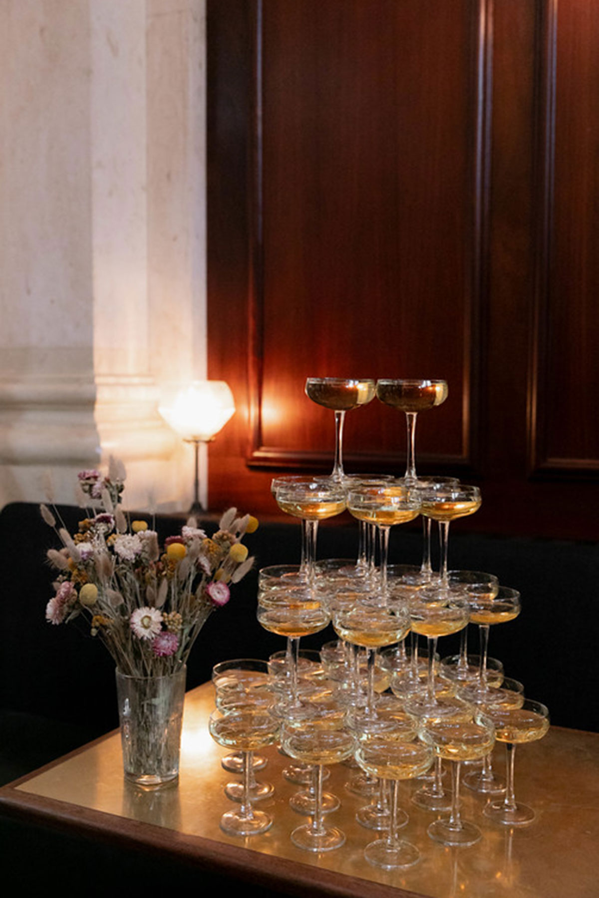 Champagne tower beside dried flowers at a wedding reception inside Hawksmoor Edinburgh.