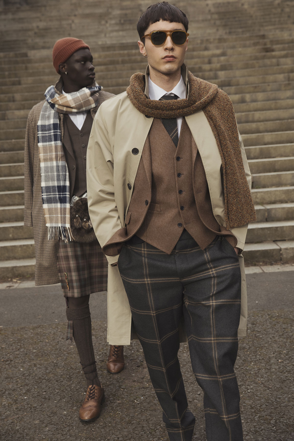 Modern groom outfit with checked trousers, waistcoat and trench coat, styled for a Scottish wedding look