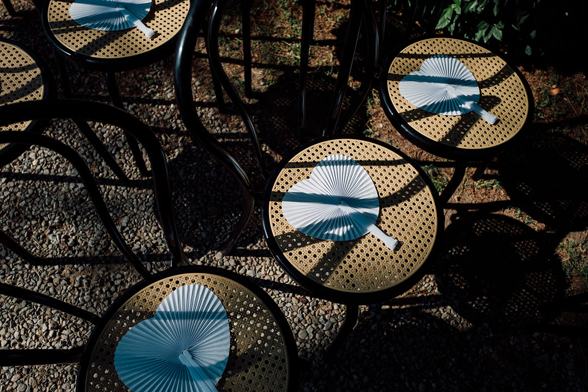 Ceremony chairs with handheld fans for summer wedding at Antico Borgo San Lorenzo Tuscany