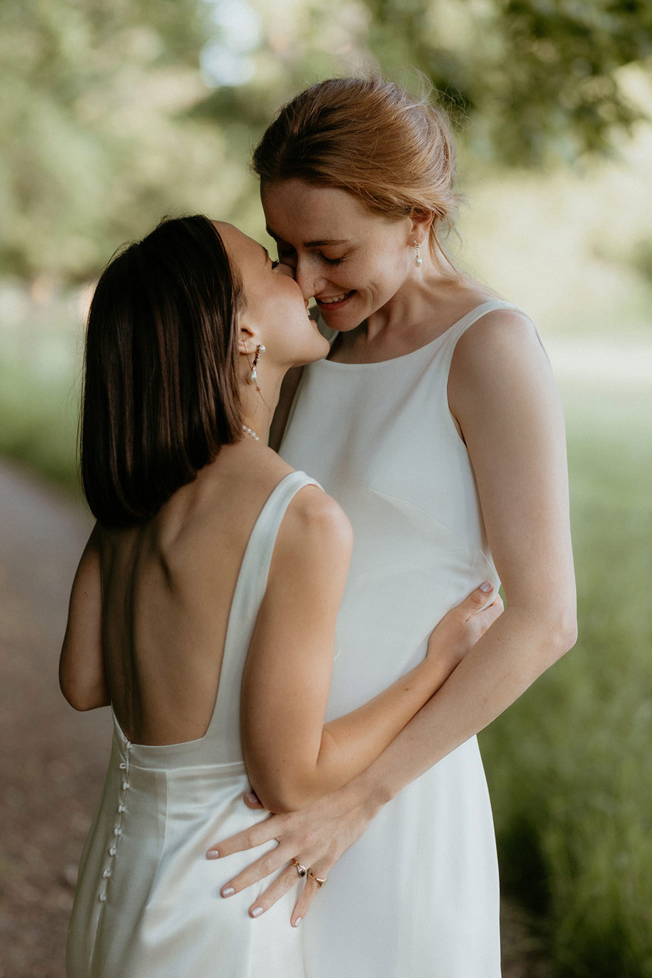 a portrait of two brides kissing in the ground of the Byre at Inchrya