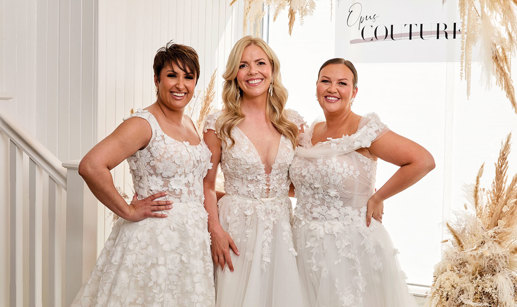 Three women standing in a row wearing wedding dresses at Opus Couture.