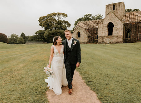 Alex and Matt Fagerson walking in grounds in front of Dunglass Collegiate Church on Dunglass Estate