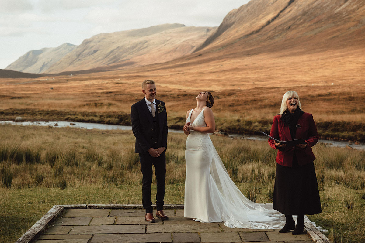 celebrant niki smith laughs with bride and groom during scottish elopement