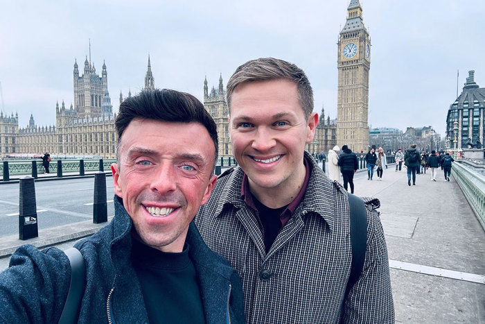 two men posing for a picture in front of Big Ben and the Houses of Parliament in London