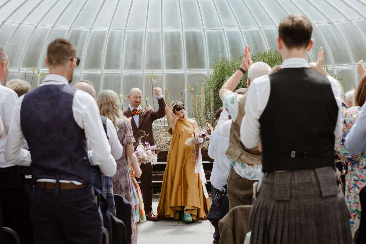 Newlyweds celebrating with guests inside the Kibble Palace in Glasgow