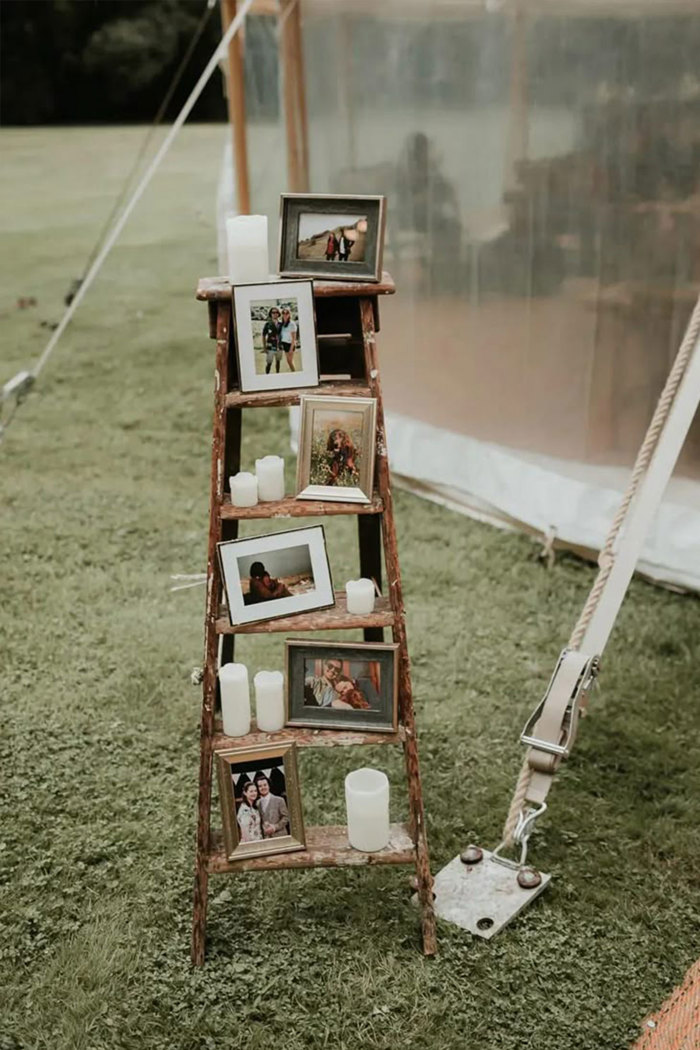 a wooden ladder with photographs and candles on it