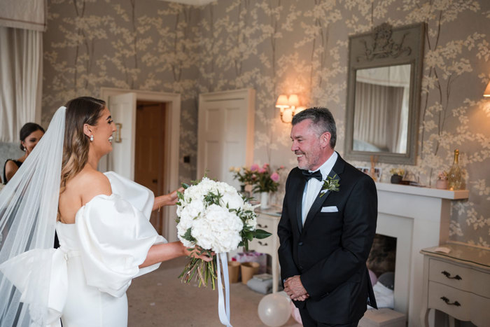 Bride goes to hug her father after first look at the dress