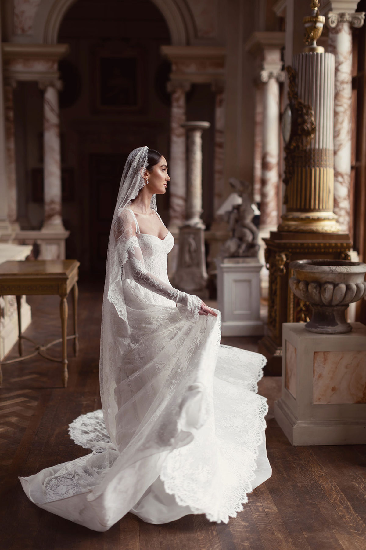 Bridal model in a lace wedding gown posed among the grand interiors of Gosford House.
