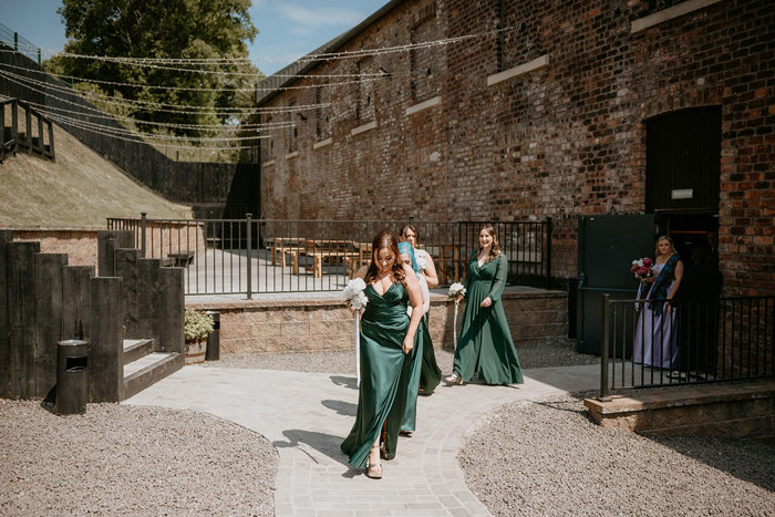 People Wearing Forest Green Long Dresses Walking Through Path On Gravel