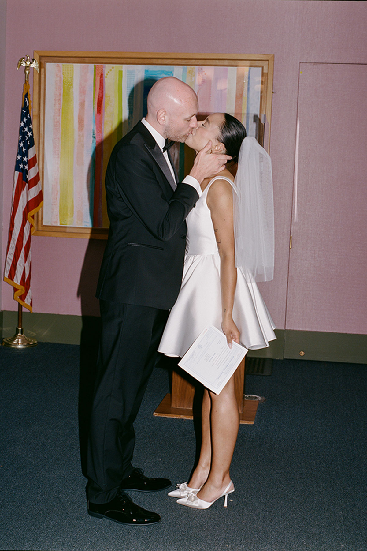 Bride and groom kissing inside New York City Hall after civil wedding ceremony