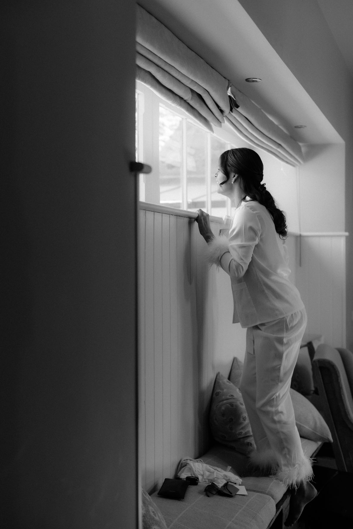 Bride getting ready by a window at The Byre at Inchyra before her Perthshire wedding ceremony.