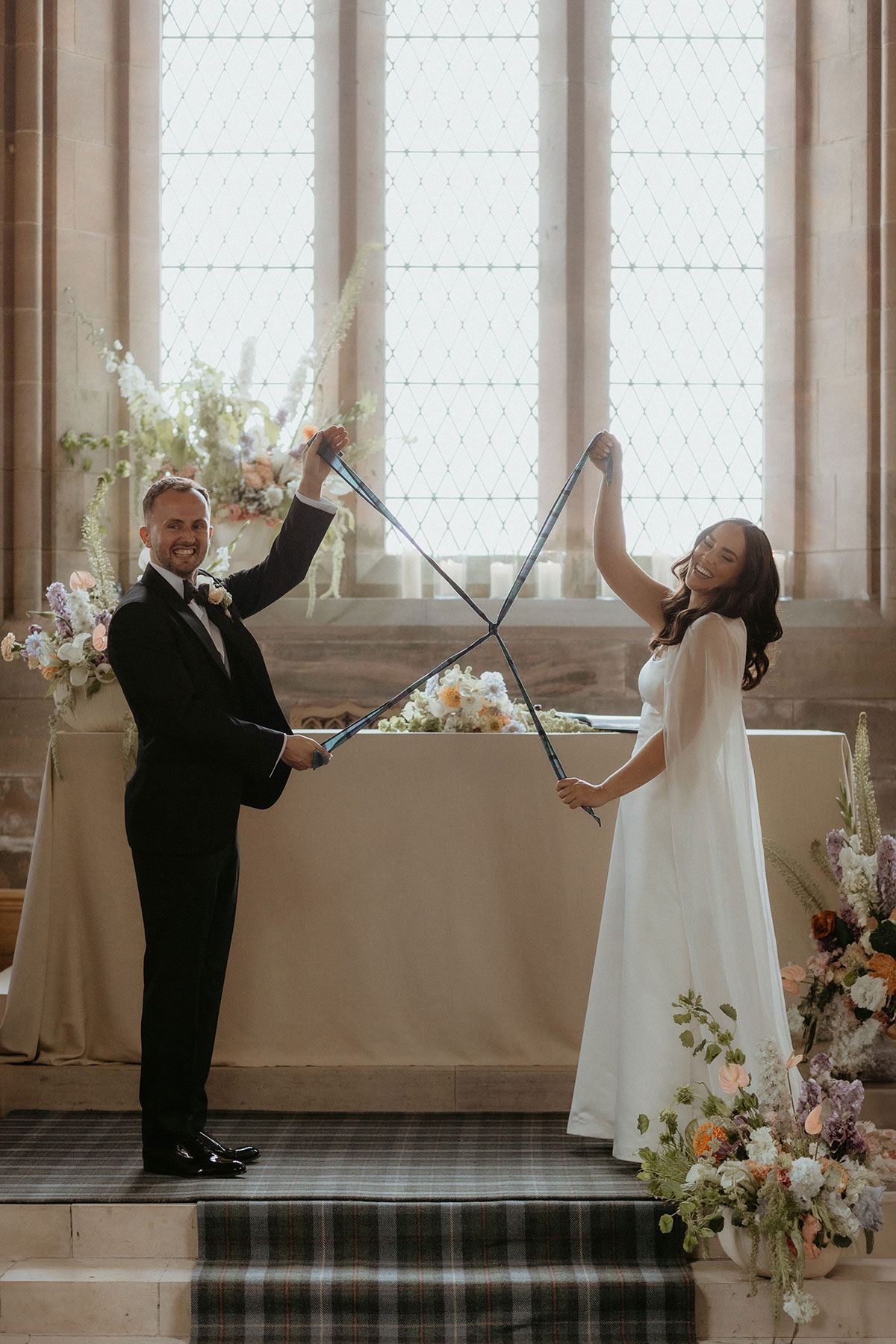 Bride and groom during handfasting ritual inside Rosebery House chapel, Midlothian humanist wedding ceremony.