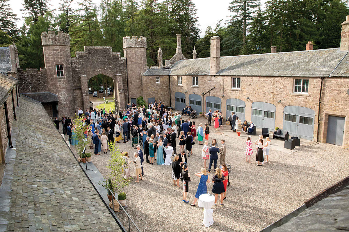 Wedding guests enjoying a drinks reception in the courtyard at Abercairny Estate, a Scottish country house wedding venue in Perthshire.