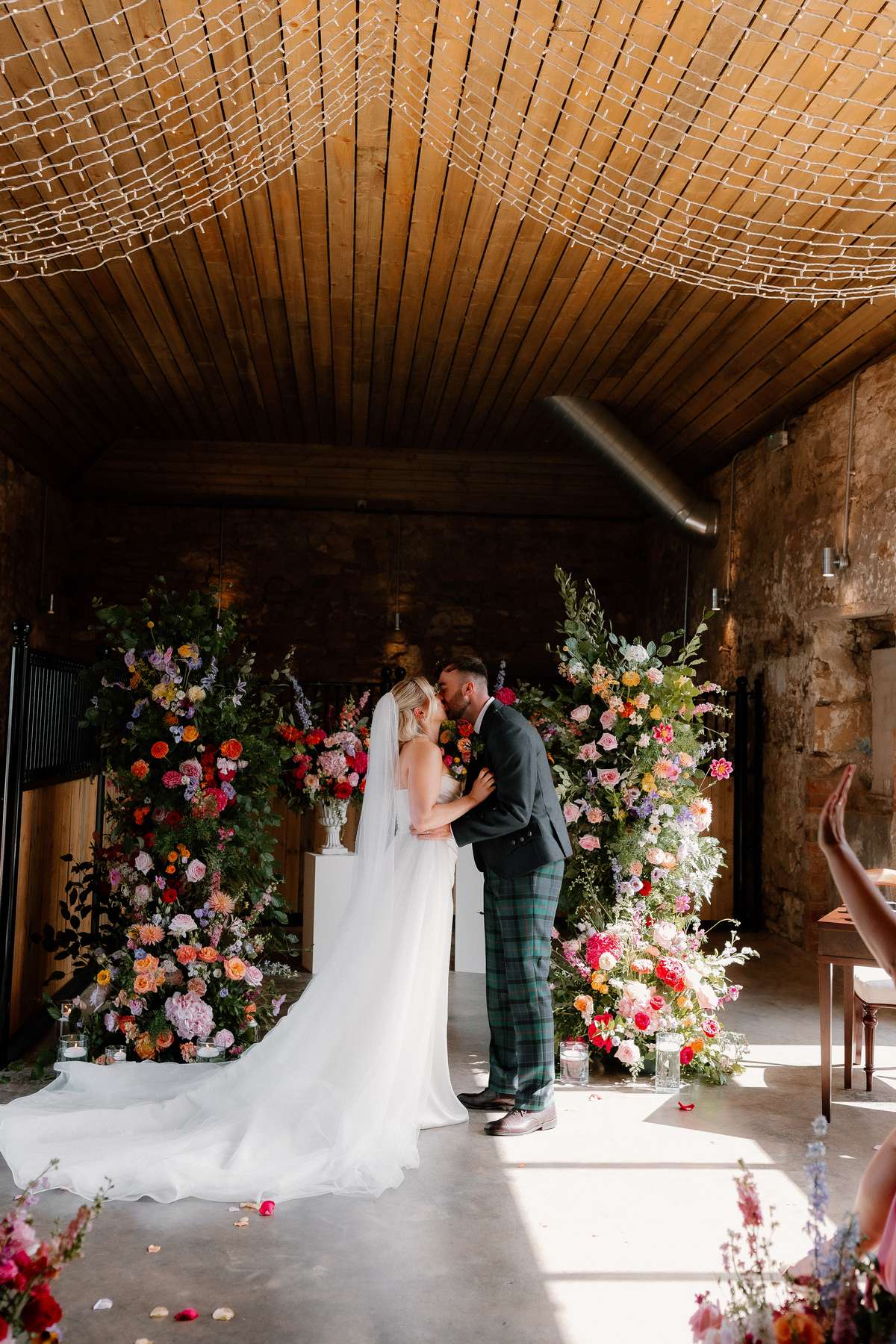 Bride and groom sharing their first kiss during a romantic wedding ceremony at Falside Mill in Fife