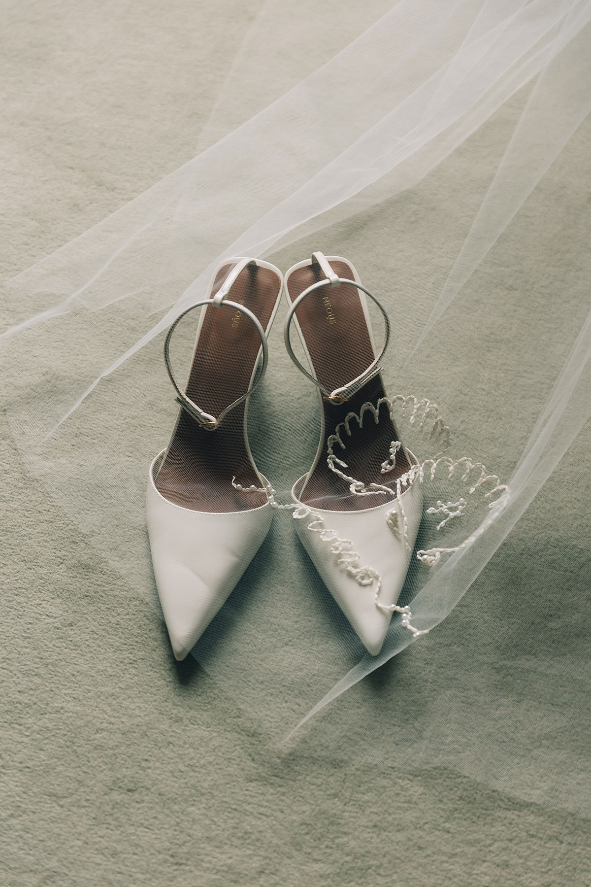 Bridal shoes with embroidered veil detail on soft fabric at Gilmerton House wedding