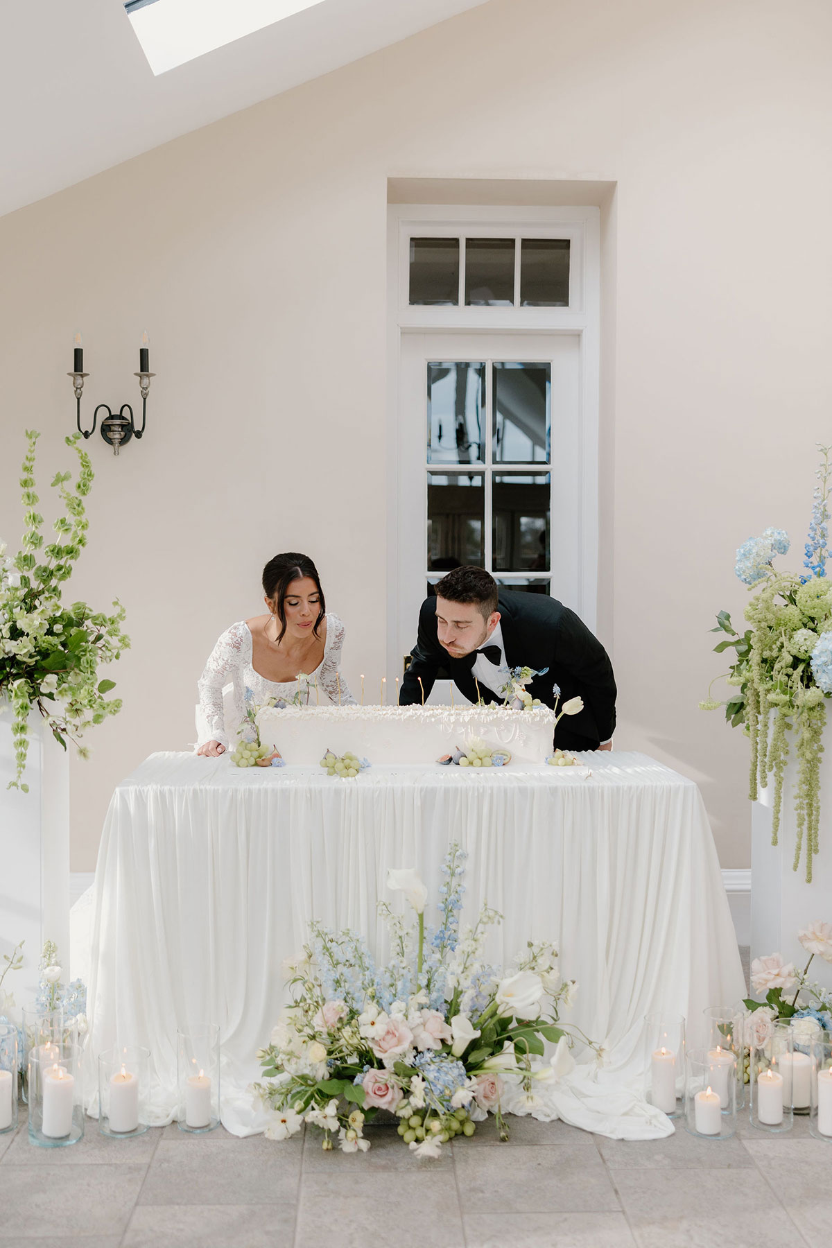 Bride and groom blowing out candles on a wedding cake