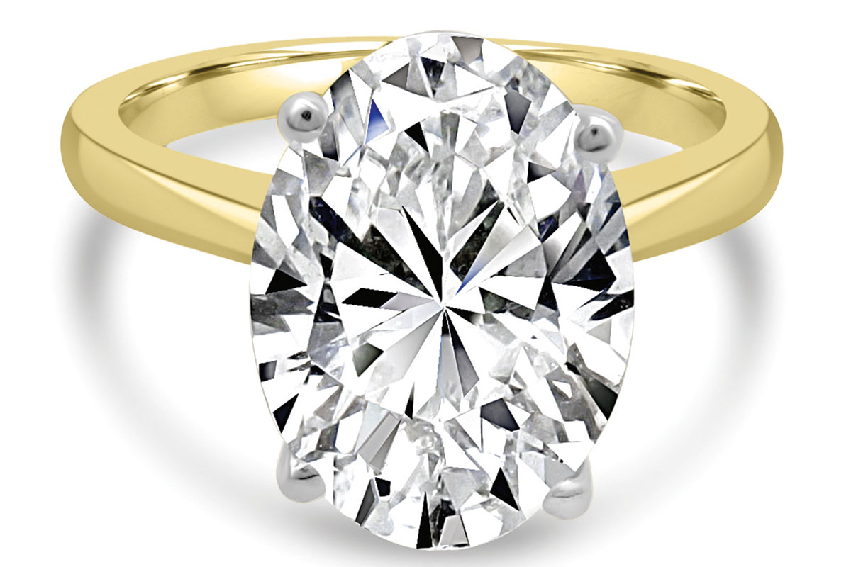 Oval diamond engagement ring with a yellow gold band and platinum dot setting from James Porter & Son.