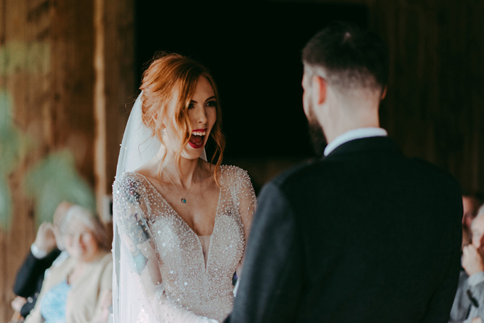 Bride looks at groom and smiles during wedding ceremony