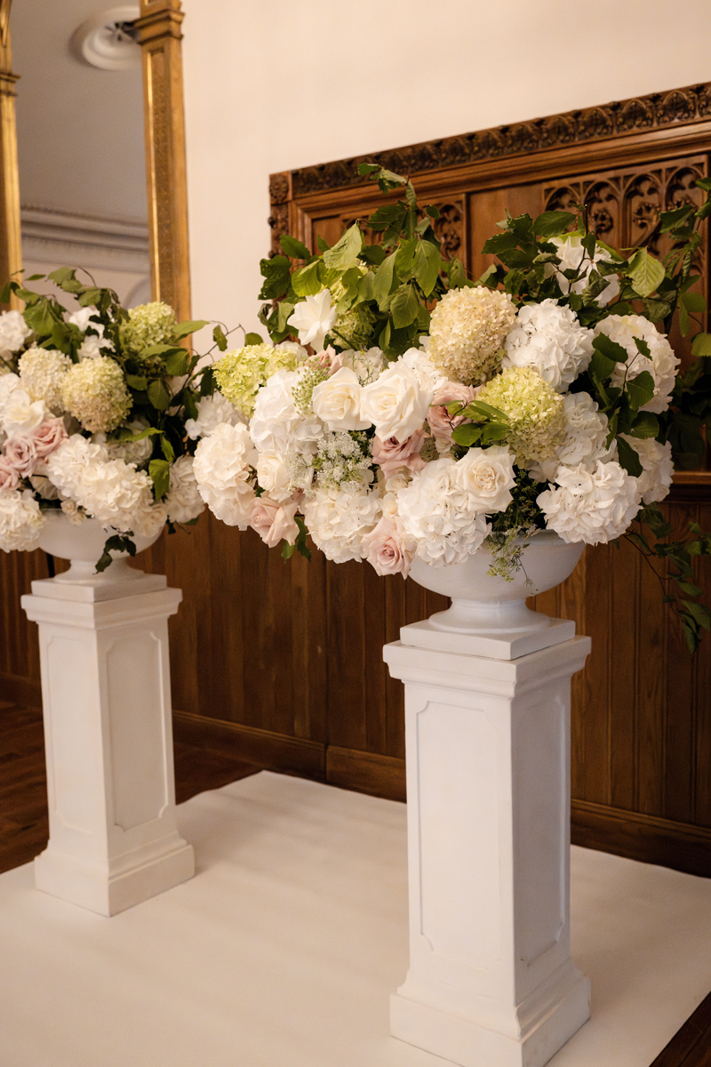Large white, blush and green floral arrangements decorating the wedding ceremony at Crossbasket Castle.