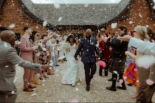 A Bride And Groom Being Showered In Confetti Outside Dougarie Boathouse
