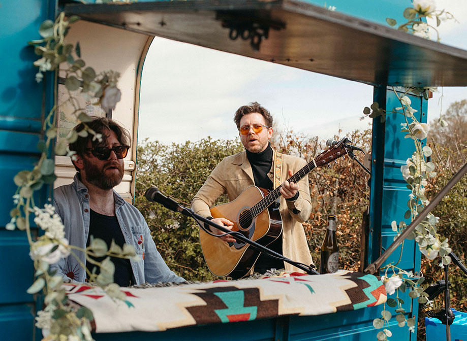 A man playing guitar and a man playing piano at Rusty's Piano Bar blue horsebox