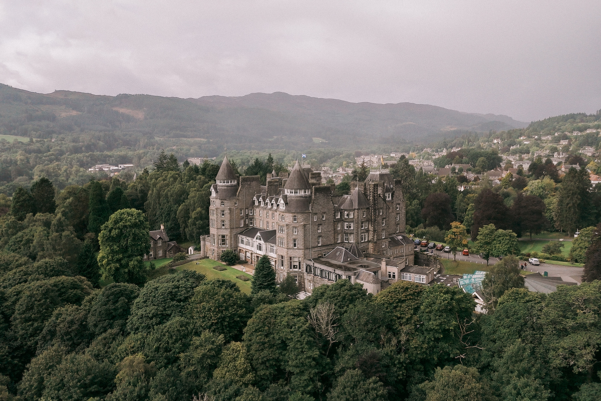 Aerial view of Atholl Palace Hotel in Pitlochry, Perthshire surrounded by woodland and Highland scenery.