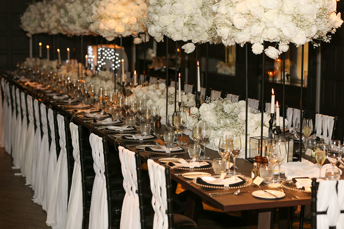 table set up for a wedding at kimpton blythswood square with black table cloth, chairs with white ribbon and white floral centrepieces