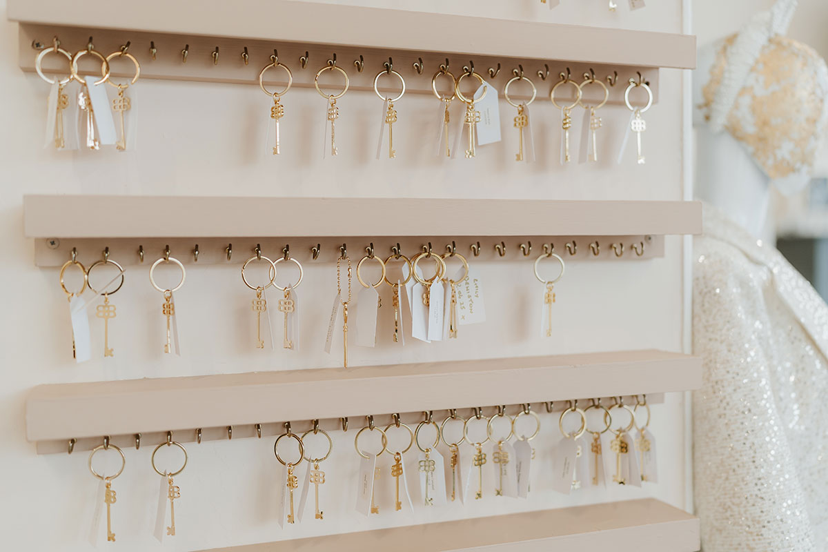 a wall display of gold keys hanging on little keychain loops