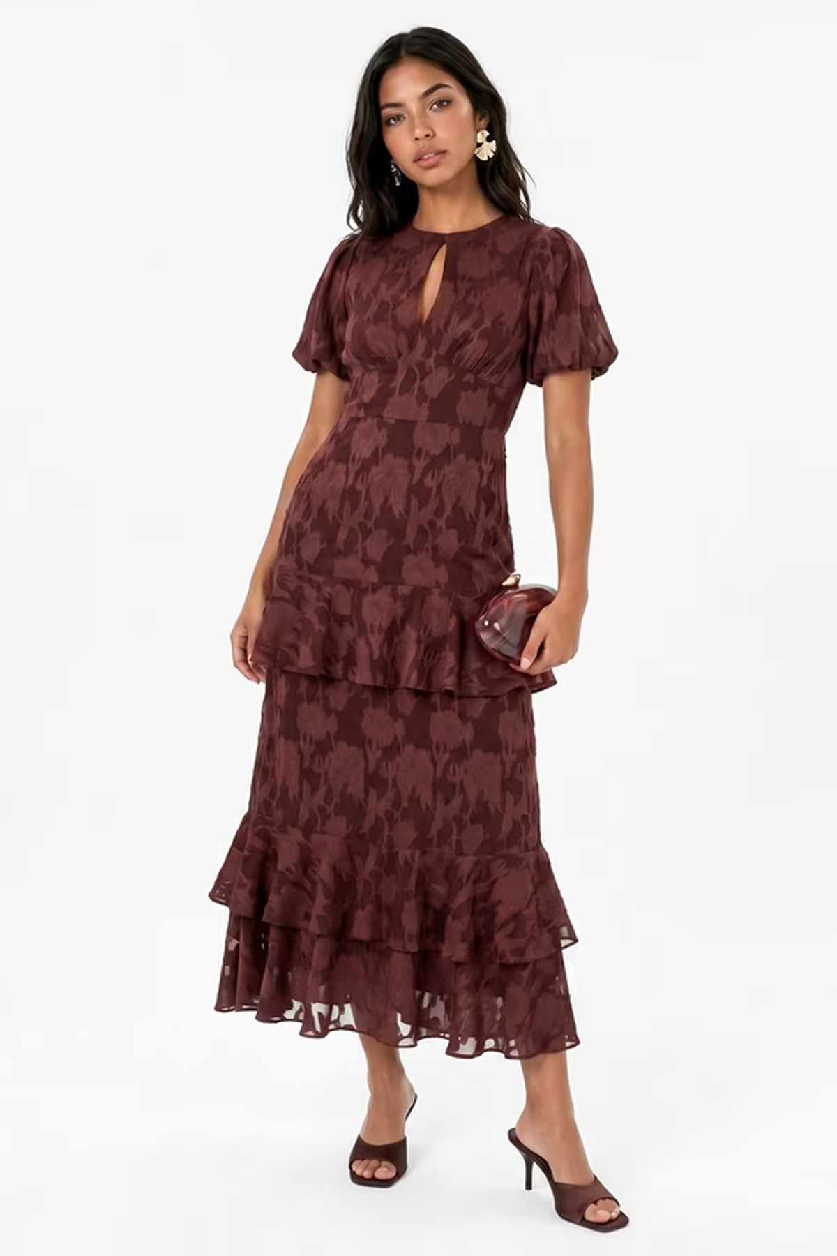 Woman wearing a chocolate-brown floral burnout maxi dress with short sleeves, a keyhole neckline and tiered ruffles.
