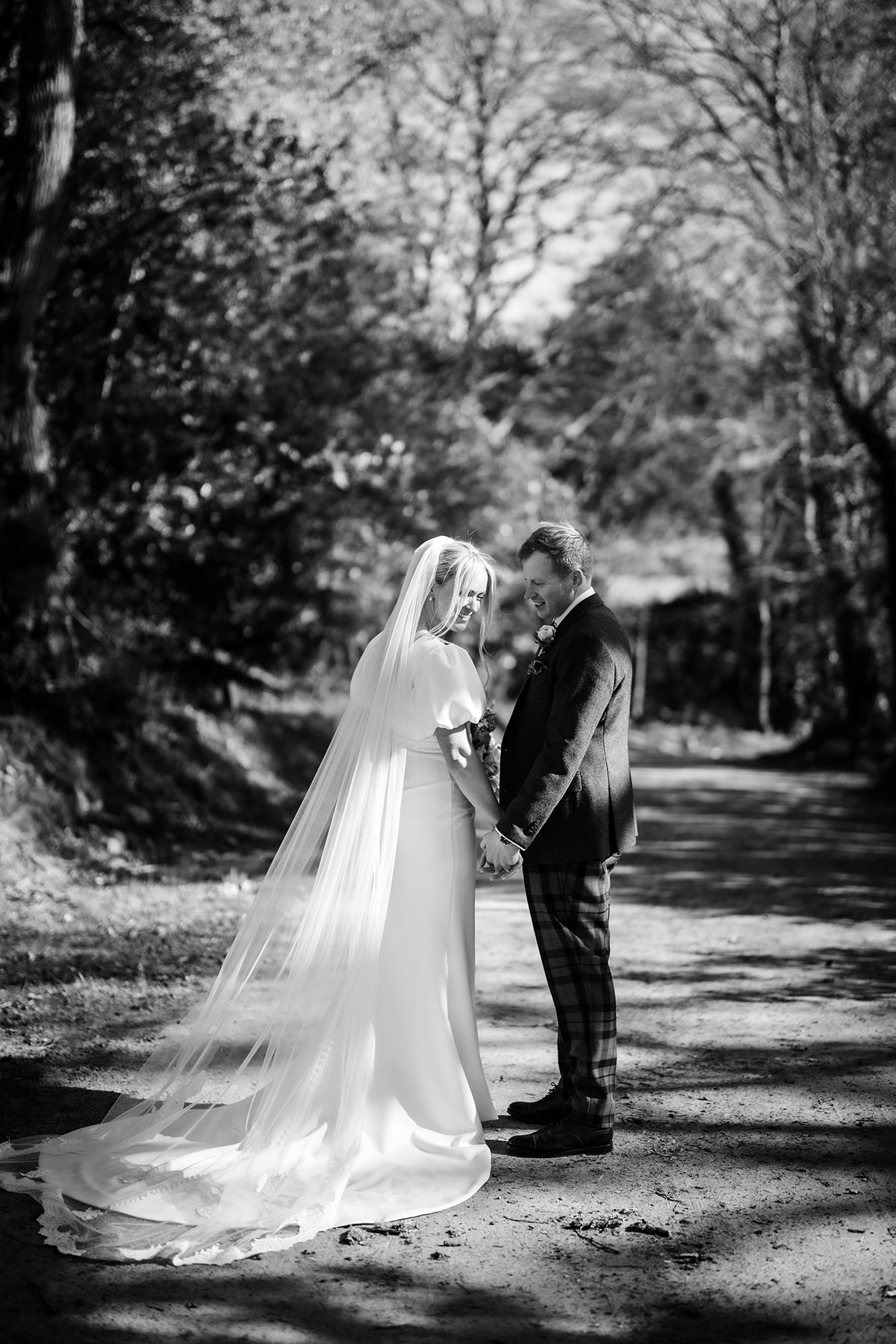 black and white picture of bride and groom underneath trees on achnagairn castle estate