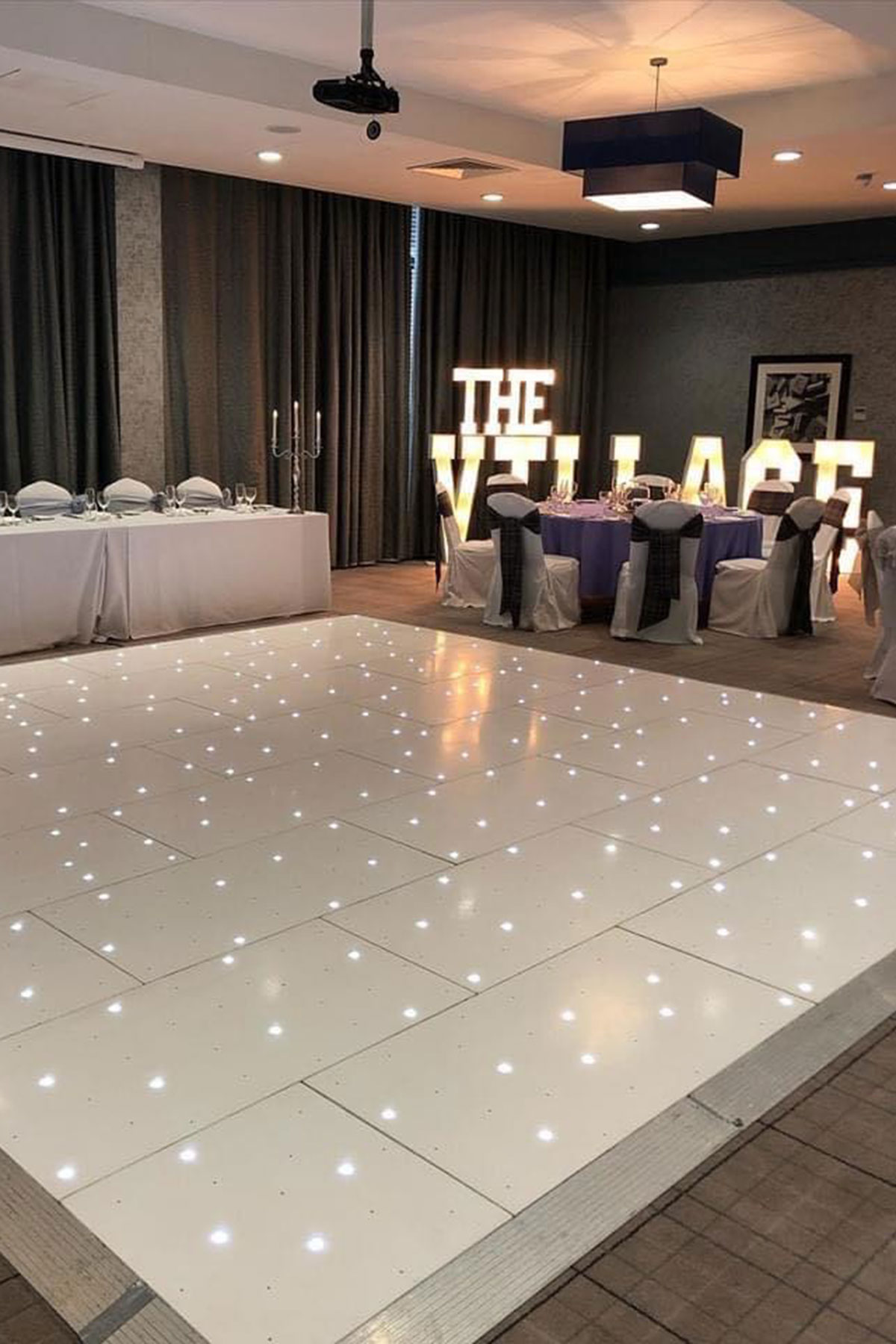 Wedding reception room with LED dance floor, illuminated LOVE letters and top table at a Scottish wedding venue