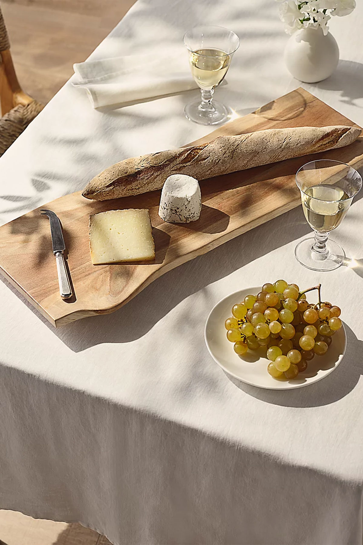 Acacia wooden serving platter with bread, cheese and grapes, a classic wedding gift idea for couples who entertain