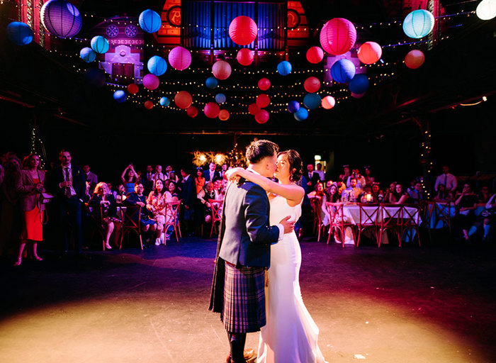 bride and groom kissing under lanterns