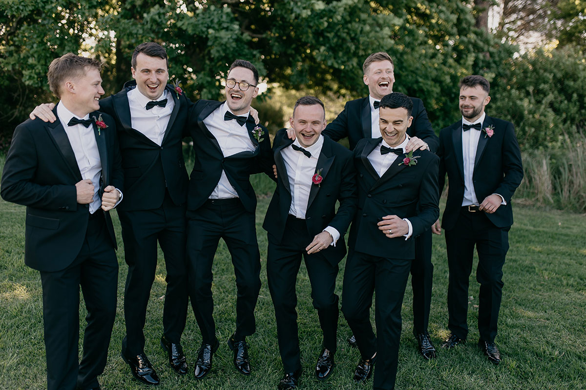 Groom and groomsmen wearing black tuxedos during portraits at Boschendal Wine Estate wedding in South Africa