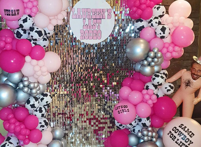 silver shimmer wall with pink balloons and cowgirl details