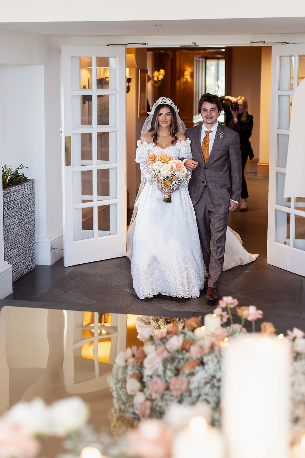 Bride and brother walking into wedding reception at Old Course Hotel, St Andrews, with candles and floral decor
