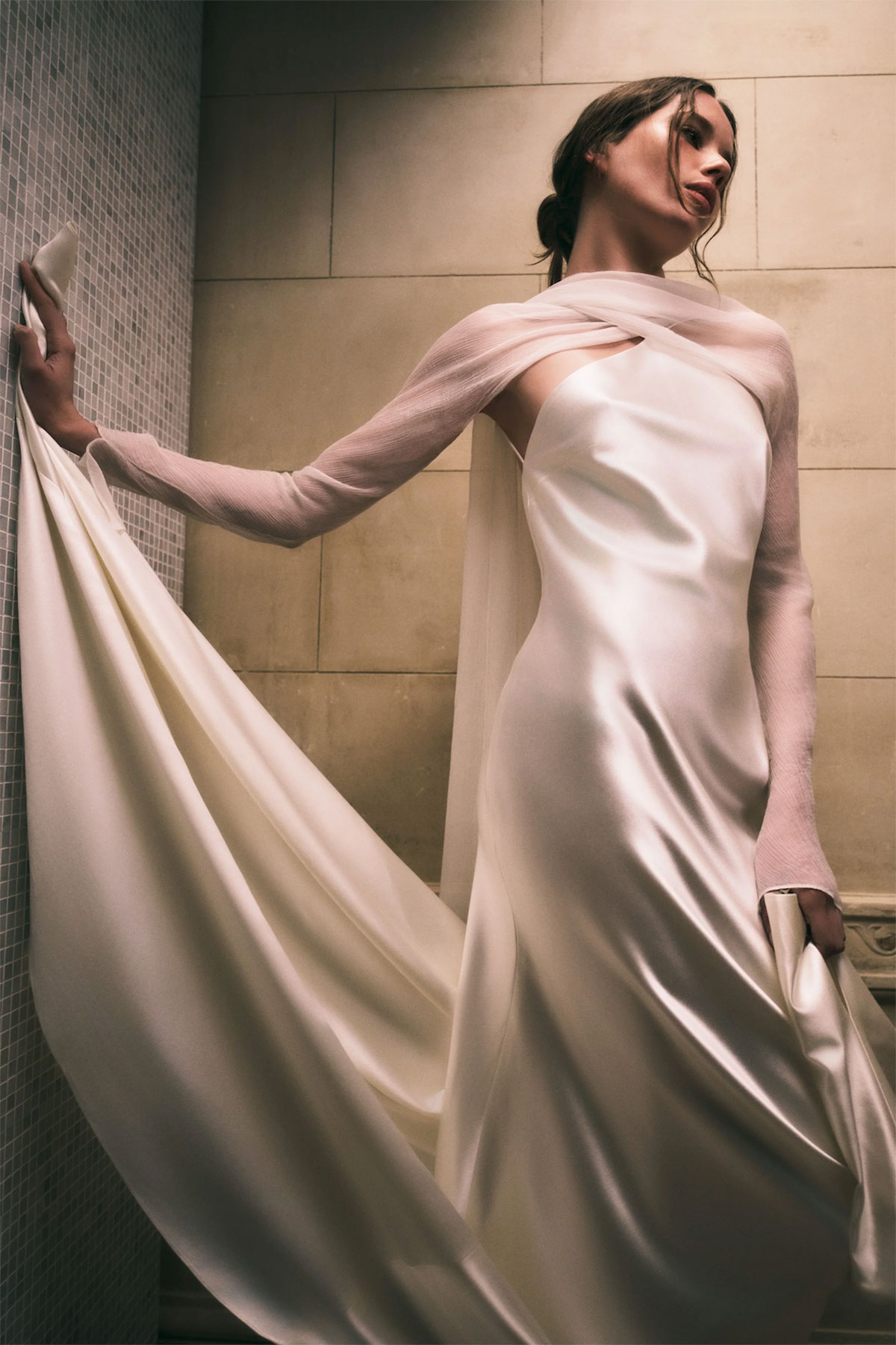 satin halter neck wedding dress on brunette model also wearing thin gauze like add-on long sleeves