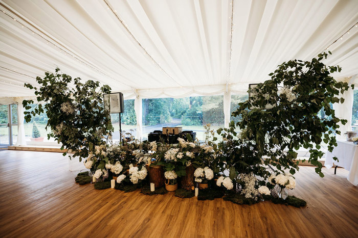 White Hydrangea And Foliage Arch Around A DJ Booth In A Marquee