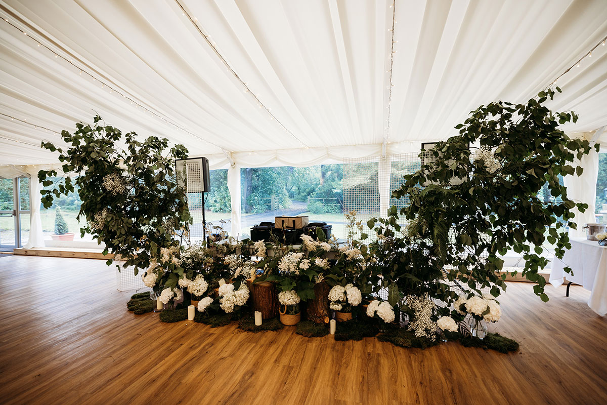 White Hydrangea And Foliage Arch Around A DJ Booth In A Marquee