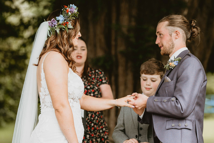 Groom puts ring on the brides finger during the ceremony