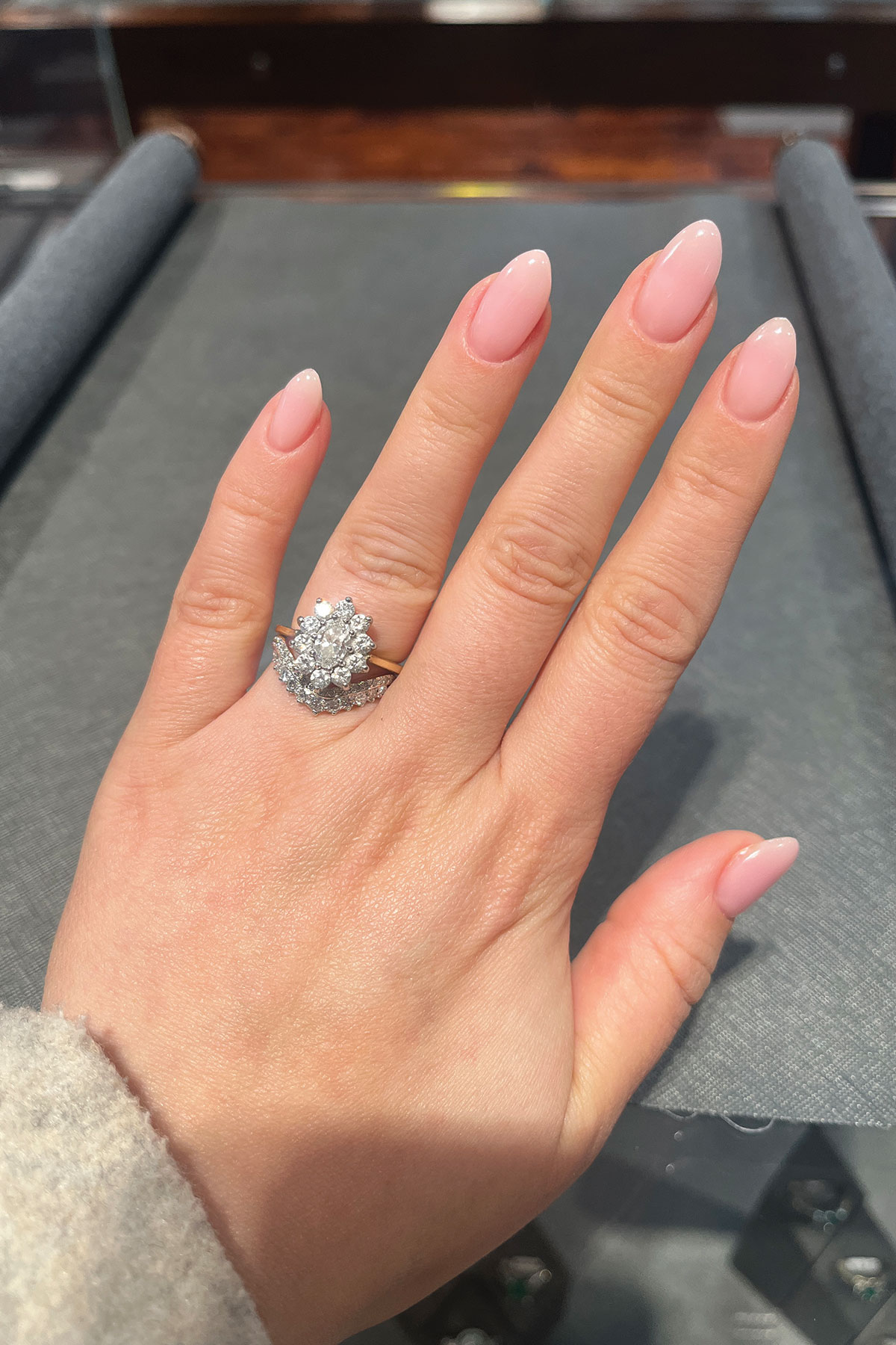 Bespoke diamond engagement ring by Tom Coll Jewellery shown on the bride’s hand.