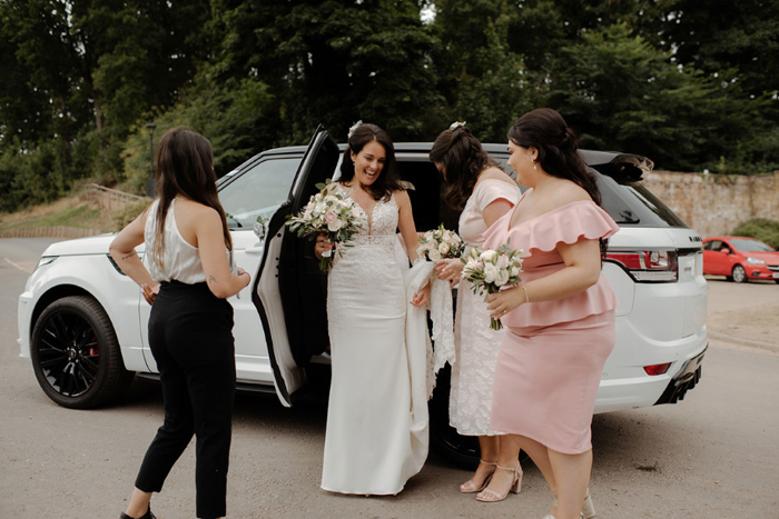 Bride gets out of white Land Rover