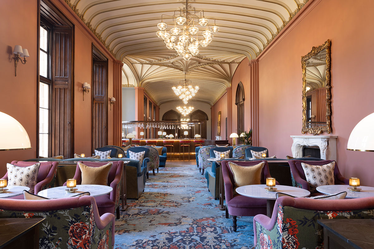 A vibrantly patterned and carpeted room with tables, chairs and a bar