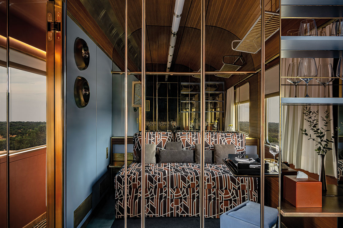 the inside of a luxury train with a geometric bed spread on the bed