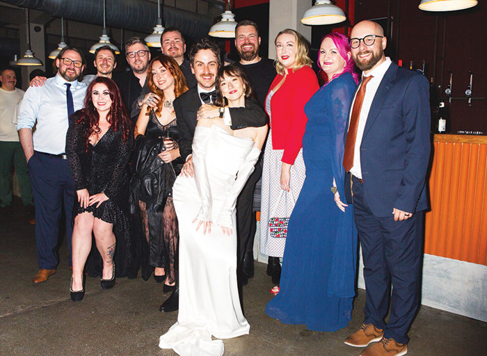 a group of people posing for a photo at a wedding 